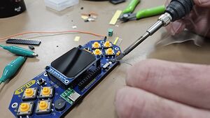 Someone soldering components on the Lilka